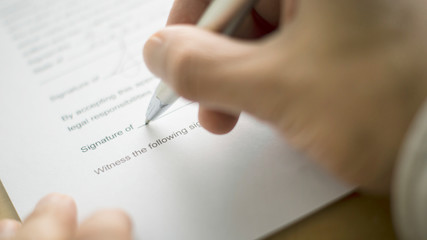 Hand signing. hand holding a pen. signing a letter.