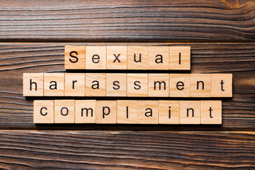 Sexual harassment complaint word written on wood block. Sexual harassment complaint text on table, concept