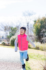春の公園で遊んでいる子供