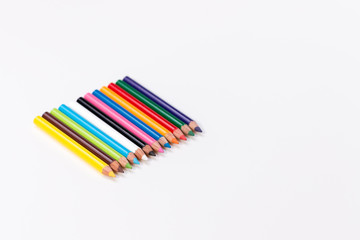 a group of twelve colorful pencils on a white background lying together
