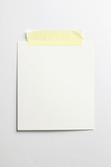 Blank polaroid photo frame with soft shadows and yellow scotch tape isolated on white paper background as template for graphic designers presentations, portfolios etc.