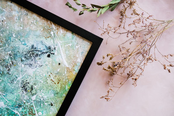 Abstract artwork in modern black frame and dried flowers. Stylish picture frame. Home decor concept.