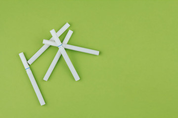 Cigarettes on a green background copy space. A few cigarettes.