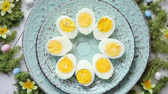 Easter table setting with flowers and eggs. Decorative plates with boiled eggs