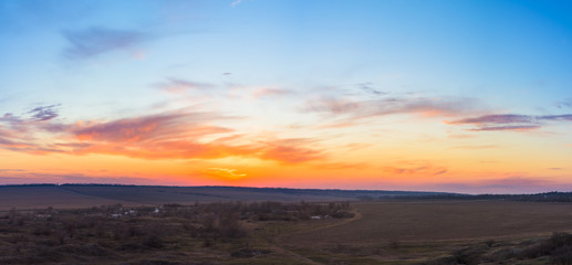 panorama of a blue-pink sunset with clouds of pink hues. sunset on the horizon. dramatic sky. photo for the banner. space for text.