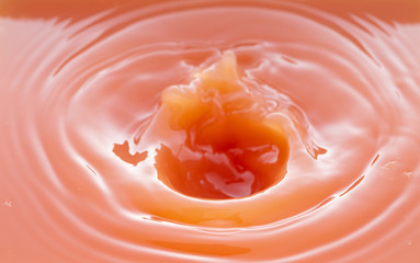 a swirling wave on the surface of grapefruit juice.