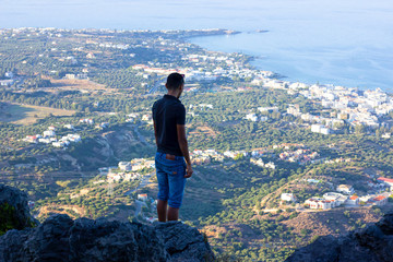 a guy resting on a mountain near the sea grece