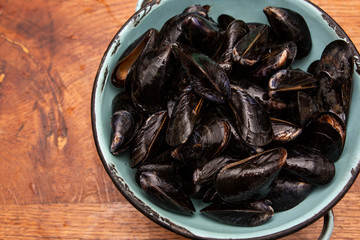 Raw mussels in a blue colander