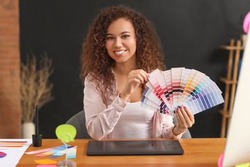 African-American designer with color palettes in office