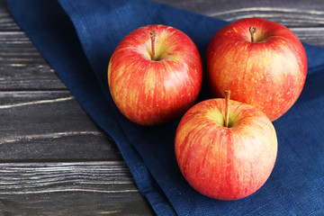 Three red apples on a dark wooden background
