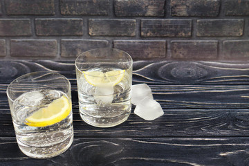 Soda water in glass glasses with lemon and ice