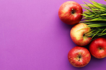 Four red apples on a purple background