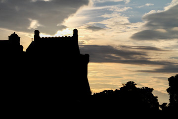 Obraz premium colored cloudy sky at valavon with the silhouette of a fortified castle and a forest