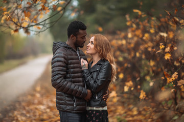 Fototapeta premium Interracial couple posing in blurry autumn park background
