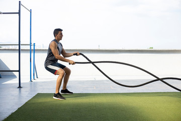 Man exercising with cross fit training rope