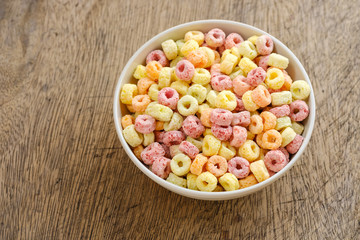 Cereal flakes in bowl with copy space,Breakfast concept.Food with delicious fruity taste and fruity colours.It's made with maize,wheat,and barley.topview and copy space.white background