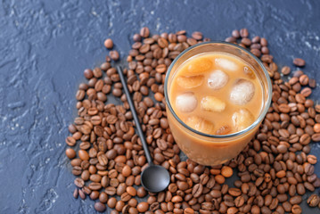 Glass of tasty iced coffee on dark background