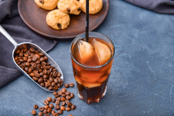 Glass of tasty iced coffee on dark background