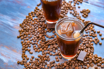 Glass of tasty iced coffee on table