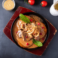 Potato pancakes with pork and sauce in a frying pan. Top view