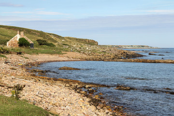  rough coastline with derelict building on the mountain side