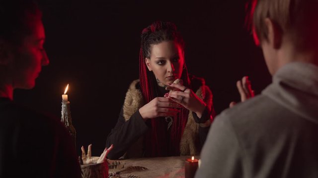 Couple listening fortune teller with voodoo doll and dreamcatcher