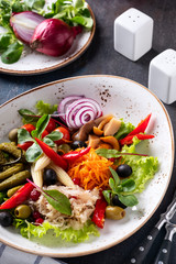 Appetizer of pickled vegetables served with fork and knife.