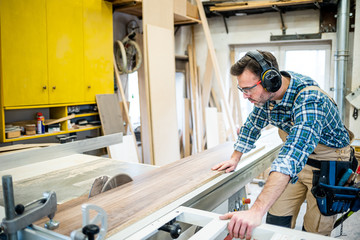 Circular saw cutting a wooden board in carpentry workshop