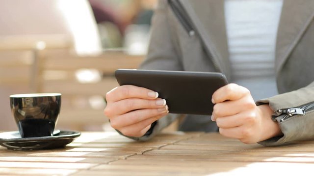 Close up of a woman hands playing game on smart phone in a coffee shop