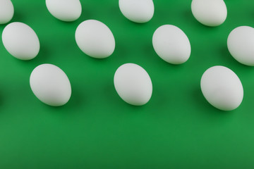 pattern of white eggs on green background top view