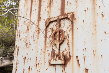 The metal symbol of the Greek Catholic Church at the gate of the abandoned Greek Orthodox Church at the end of the street in the old district of Jerusalem city in Israel