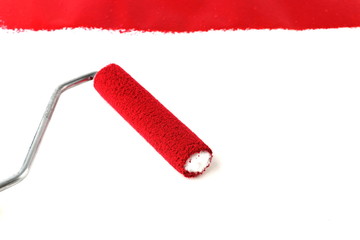 red paint and painting roller on white background
