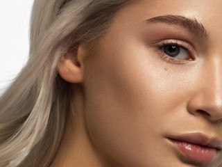 Fototapeta premium Half a beauty portrait with beautiful fashionable evening make-up, natural eyes and extremely long eyelashes. Nude lipstick on the lips. Cosmetology and spa facial skin care