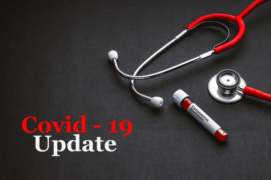 COVID 19 UPDATE text with stethoscope and blood sample vacuum tube on black background. Covid or Coronavirus Concept