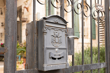 A metal mailbox with the emblem of the Jerusalem Post hangs on a metal fence in the old district of Jerusalem city in Israel