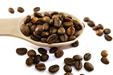 roasted coffee beans in a wooden spoon on a white background. View from above. Close-up.