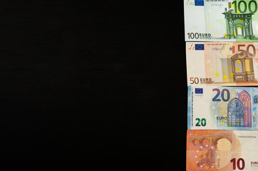 folded euro banknotes on a black background. Space for text. Business concept.