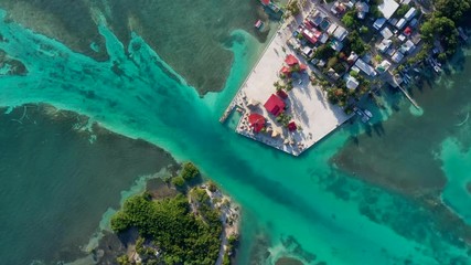 Aerial, screwdriver, drone shot top down above the split lagoon, and the Caye Caulker island, on a sunny day, in Belize, Central America