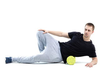 A man makes strengthening exercises for the body with special sports equipment. Self massage increases the body's tone