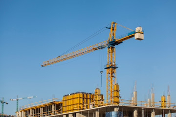 Construction site with crane against the blue sky	