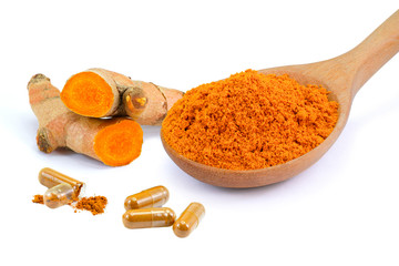 Turmeric powder in wooden bowl and spoon with curcuma ground root and turmeric capsules isolated on white  background. Natural medicine plant ,alternative medical health care and supplement concept . 