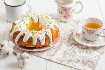 Easter cake on a white table, tea, cotton flower, milk, food concept on Easter table