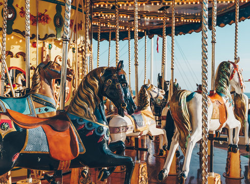 carousel in an amusement holiday park. Merry-go-round with horses on a fairground vintage carousel.
