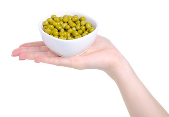 Hand holding white bowl with canned green pea on white background isolation