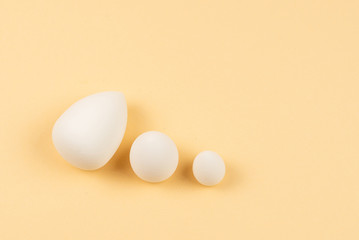 Small, medium and large white beauty blender on beige background.