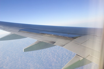 Airplane wing in the sky. View from a great height.