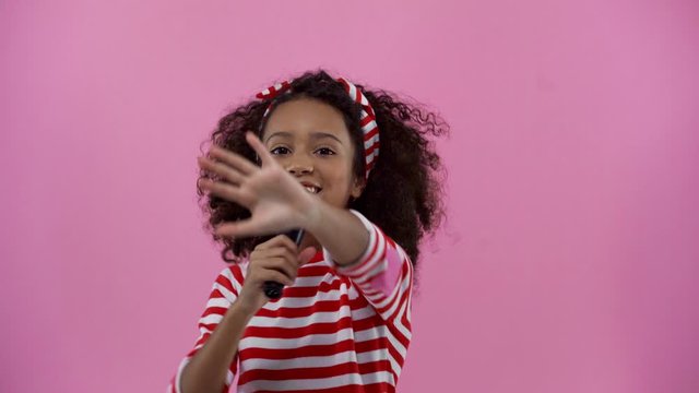 happy african american kid singing isolated on pink