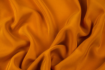 Fototapeta premium Golden silk or satin luxury fabric texture can use as abstract background.