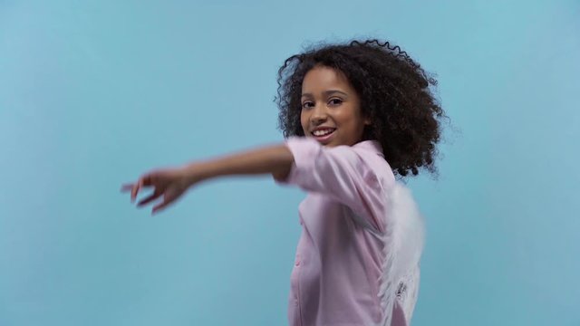 african american kid with angel wings dancing isolated on blue