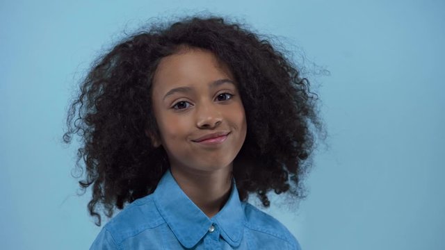 cheerful african american kid smiling isolated on blue